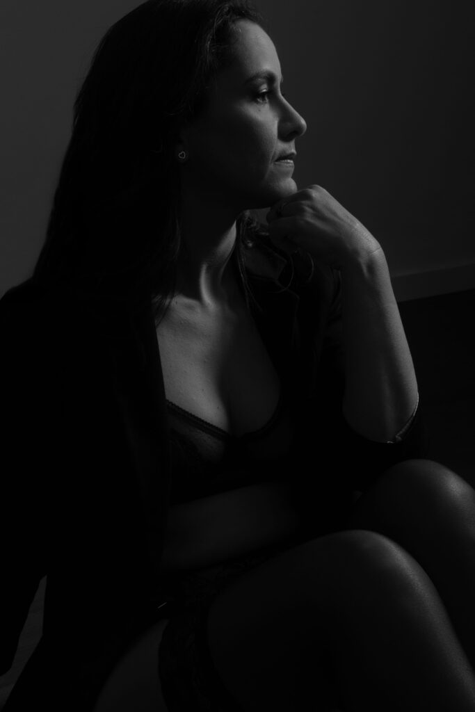 Retrato intimista feminino em luz lateral dramática, com expressão serena e pose elegante, fotografado em estúdio por Danniela Senra em Castelo Branco