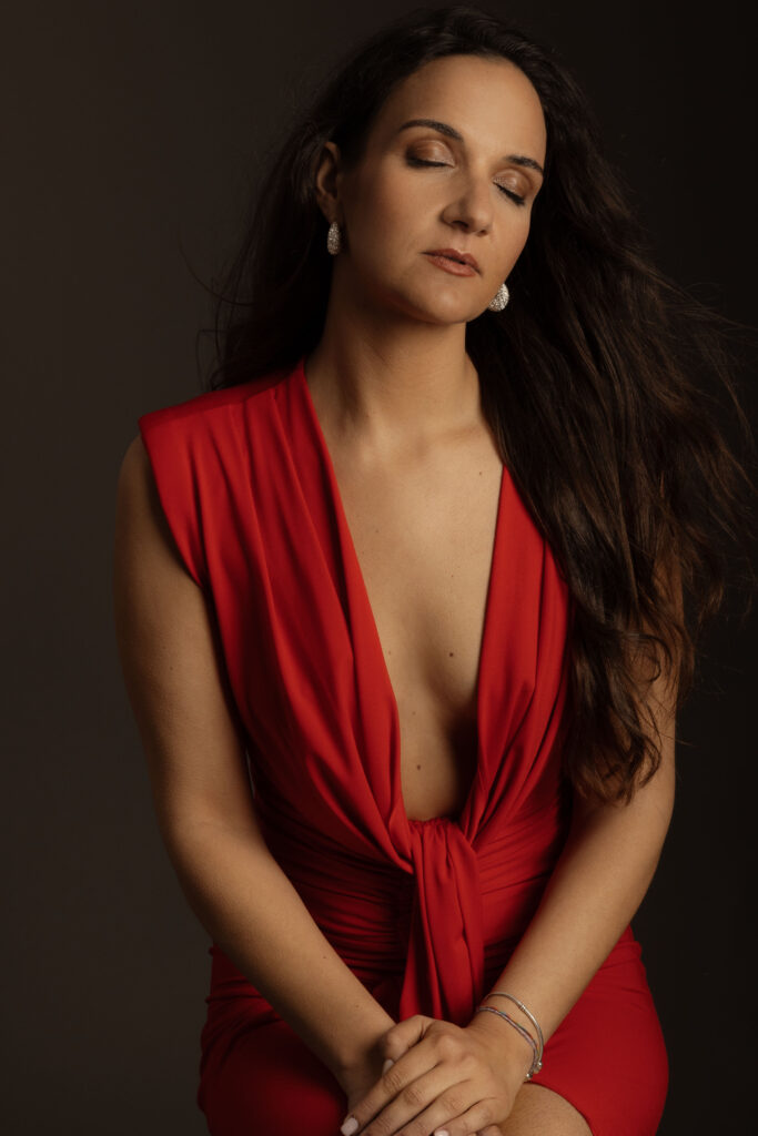 Retrato feminino editorial em estúdio com vestido vermelho e expressão serena, fotografado por Danniela Senra em Castelo Branco