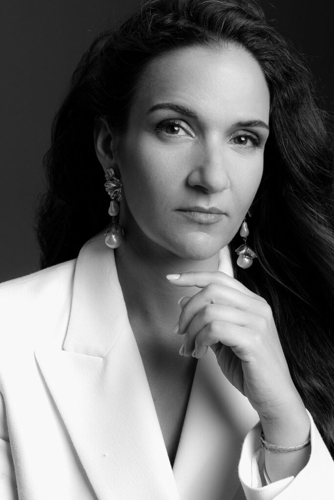 Retrato feminino editorial em estúdio com styling em fato branco e expressão elegante, fotografado por Danniela Senra em Castelo Branco