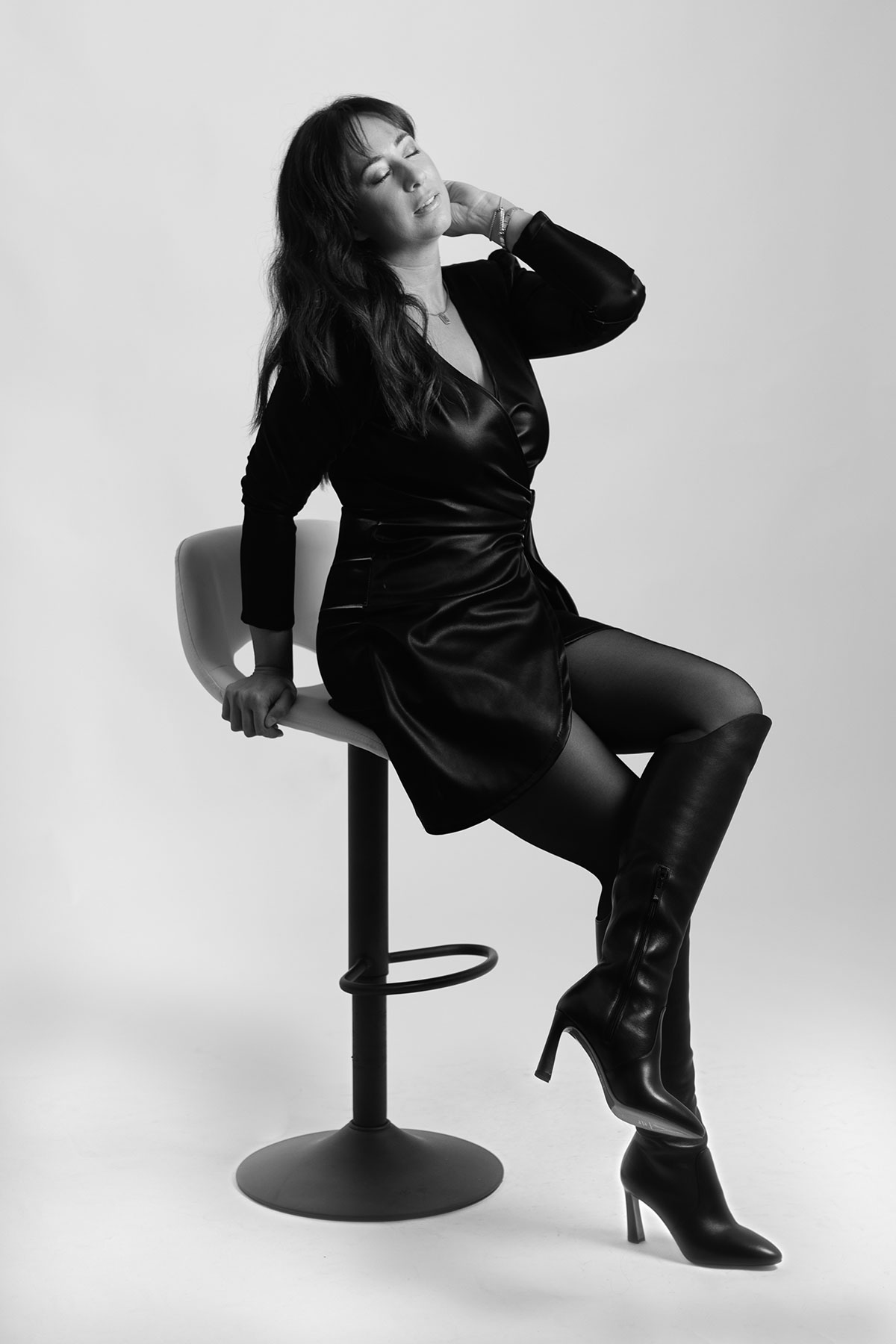 Retrato feminino editorial em estúdio com styling em vestido preto e botas de salto alto, fotografado por Danniela Senra em Castelo Branco