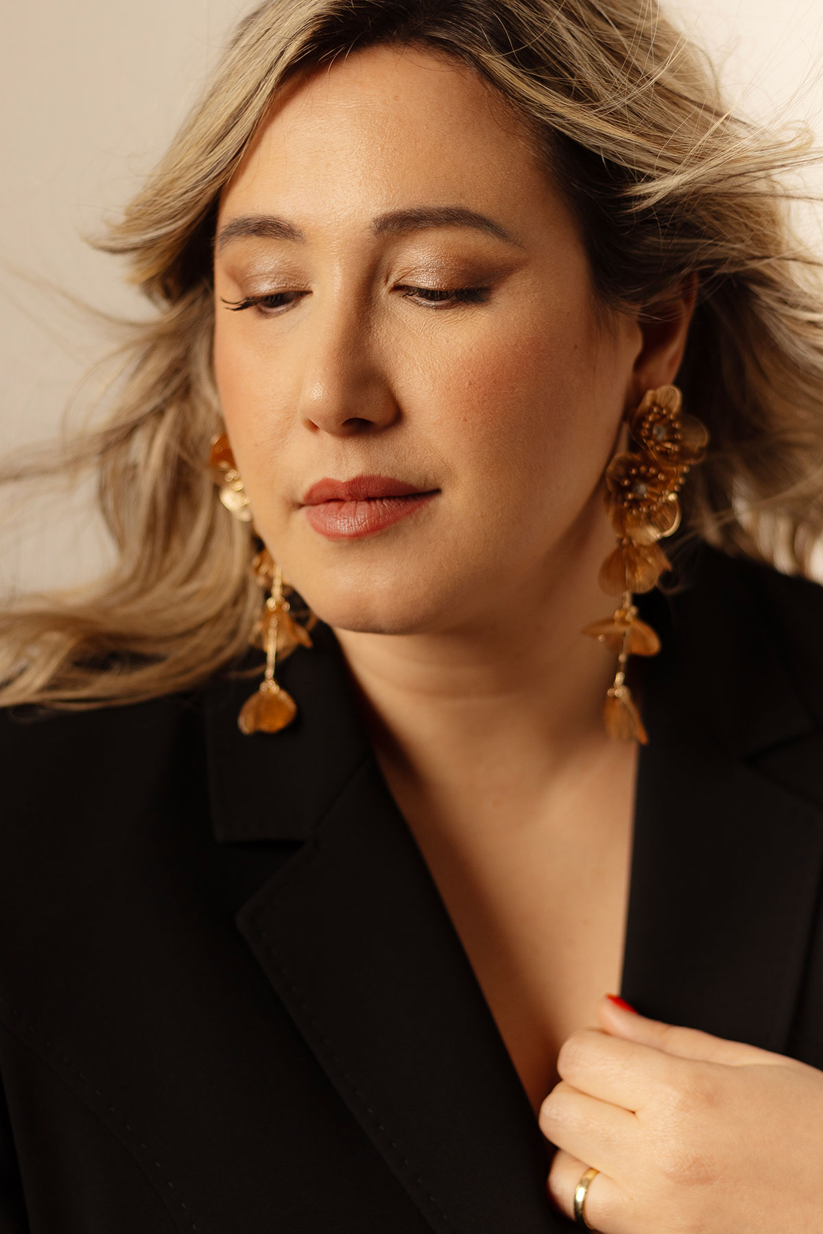 Retrato feminino editorial em estúdio com blazer preto, brincos dourados e olhar sereno, fotografado por Danniela Senra em Castelo Branco