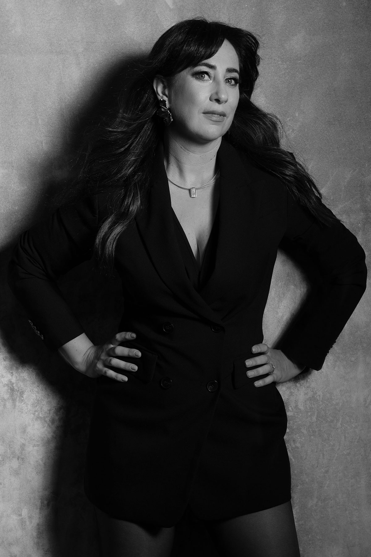 Retrato feminino editorial em estúdio, com vestido preto e expressão confiante, fotografado por Danniela Senra em Castelo Branco