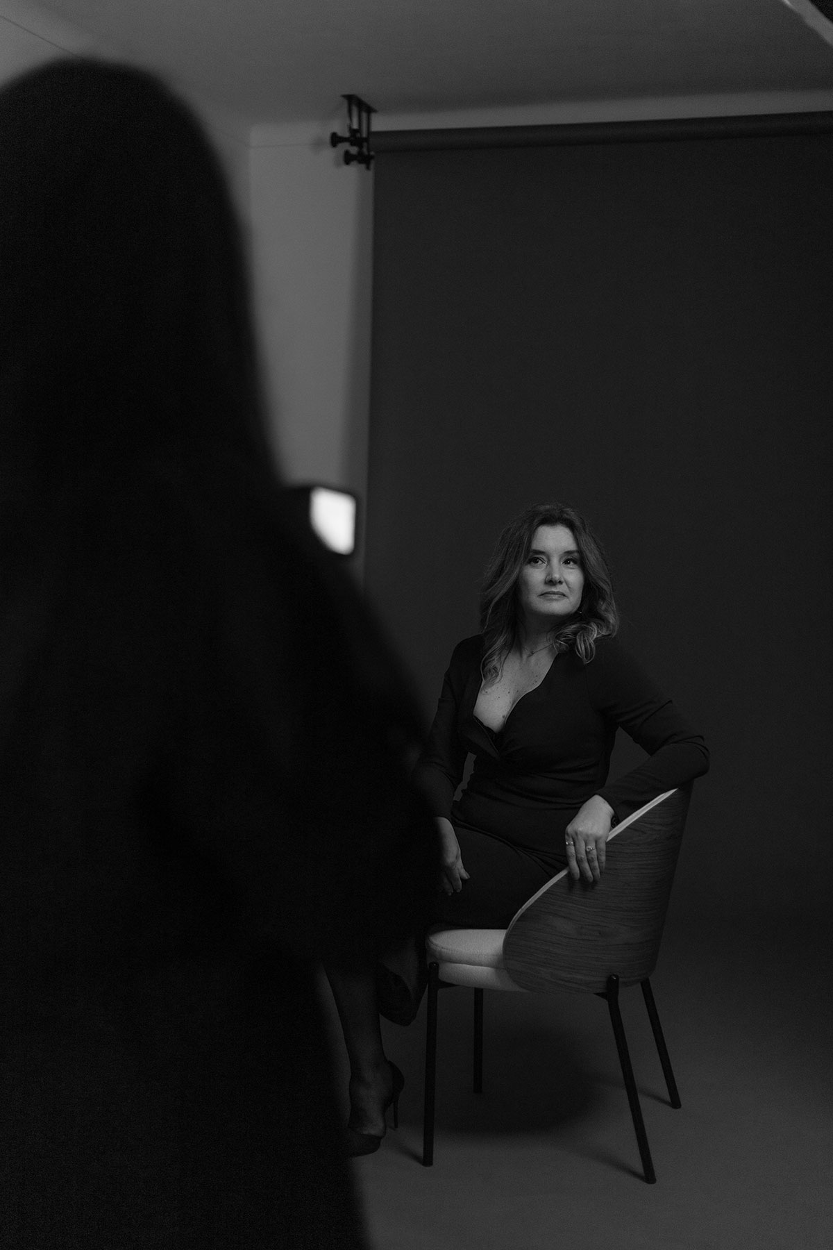 bastidores de uma mulher sentada a olhar para a câmera