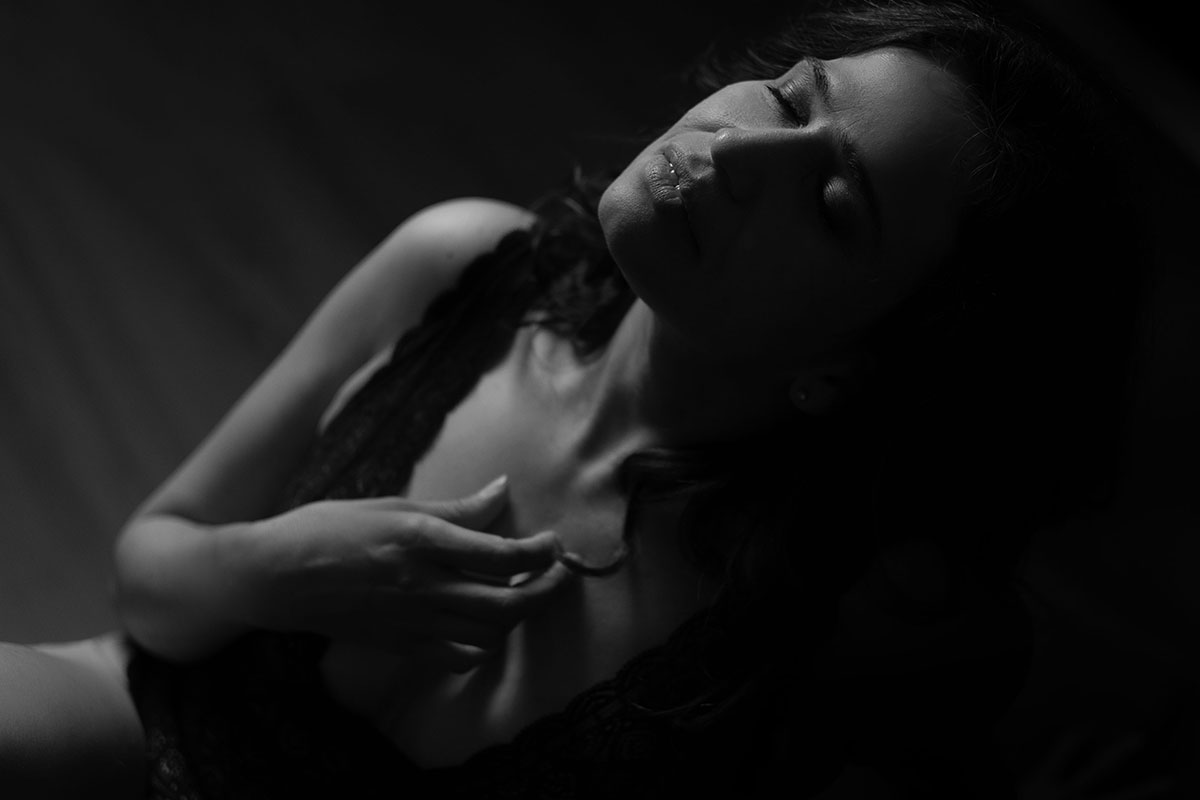 retrato intimista, na horizontal, mulher com a mão no peito, olhos fechados, preto e branco