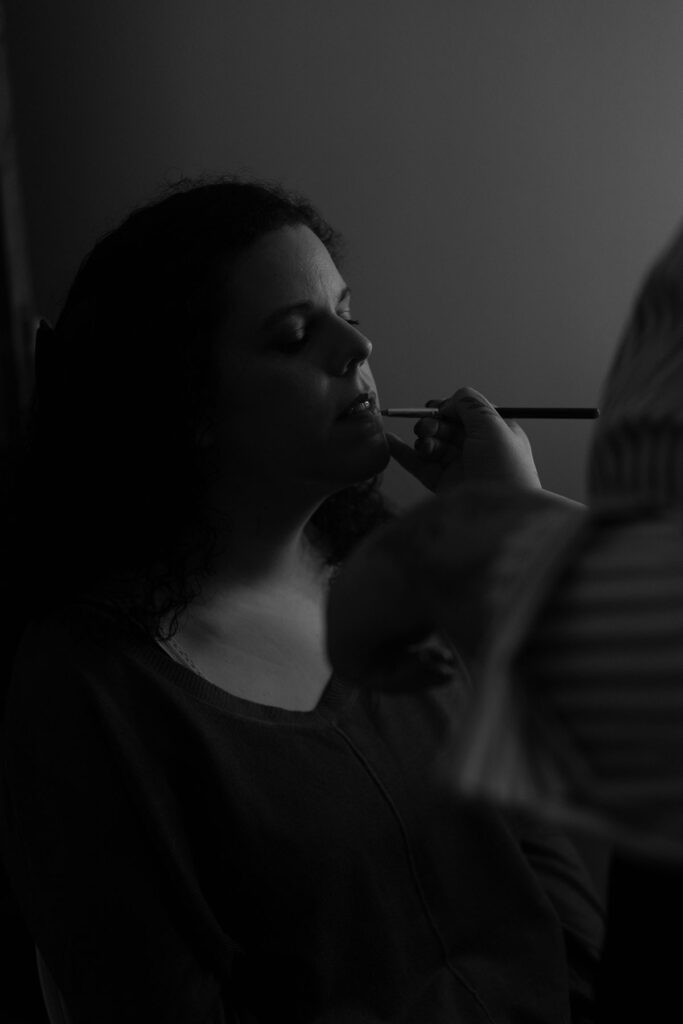 bastidores de uma mulher sendo maquilhada pela fotografa