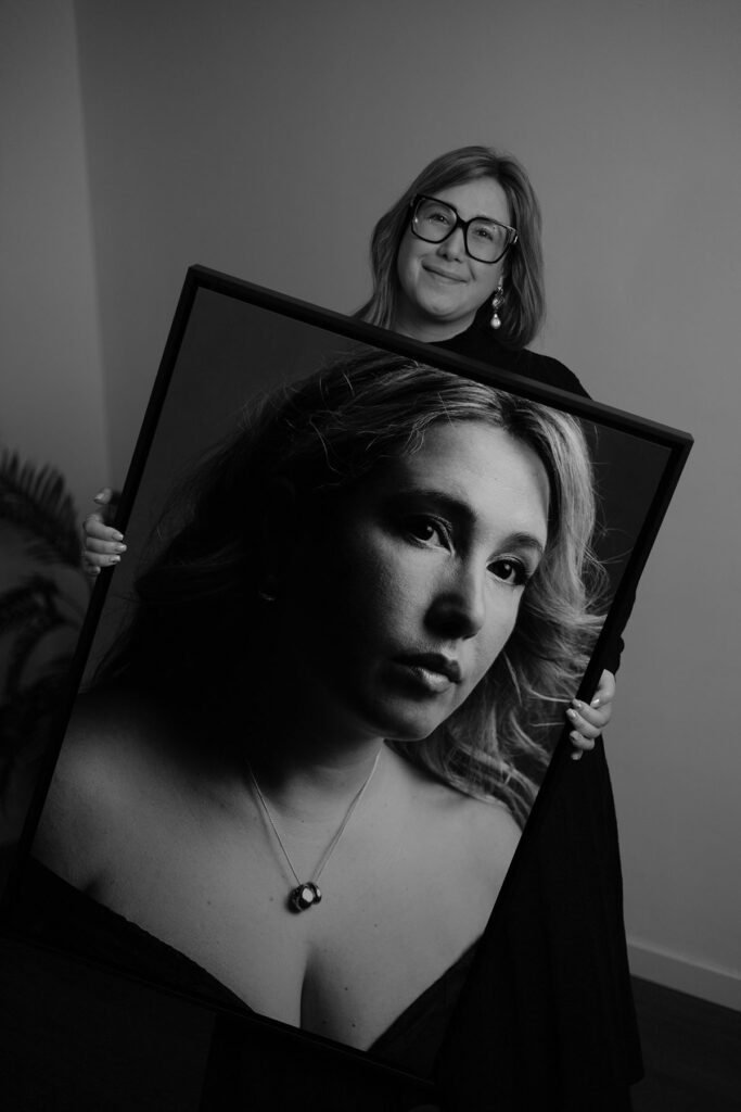 entrega de um quadro preto com a foto da mulher que esta a segurar