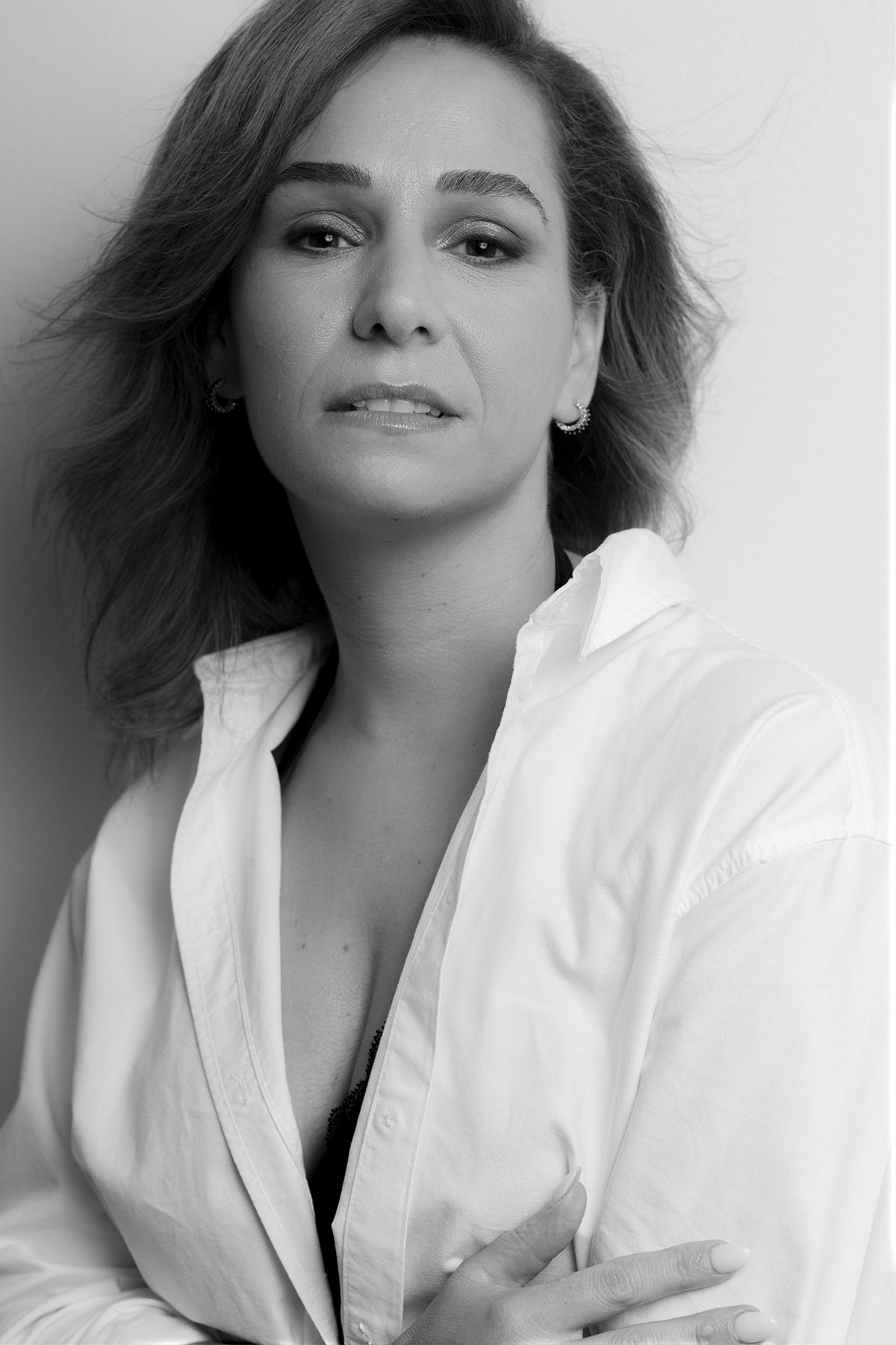 Retrato feminino em estúdio com camisa branca, pose confiante e estética editorial — fotografia por Danniela Senra em Castelo Branco