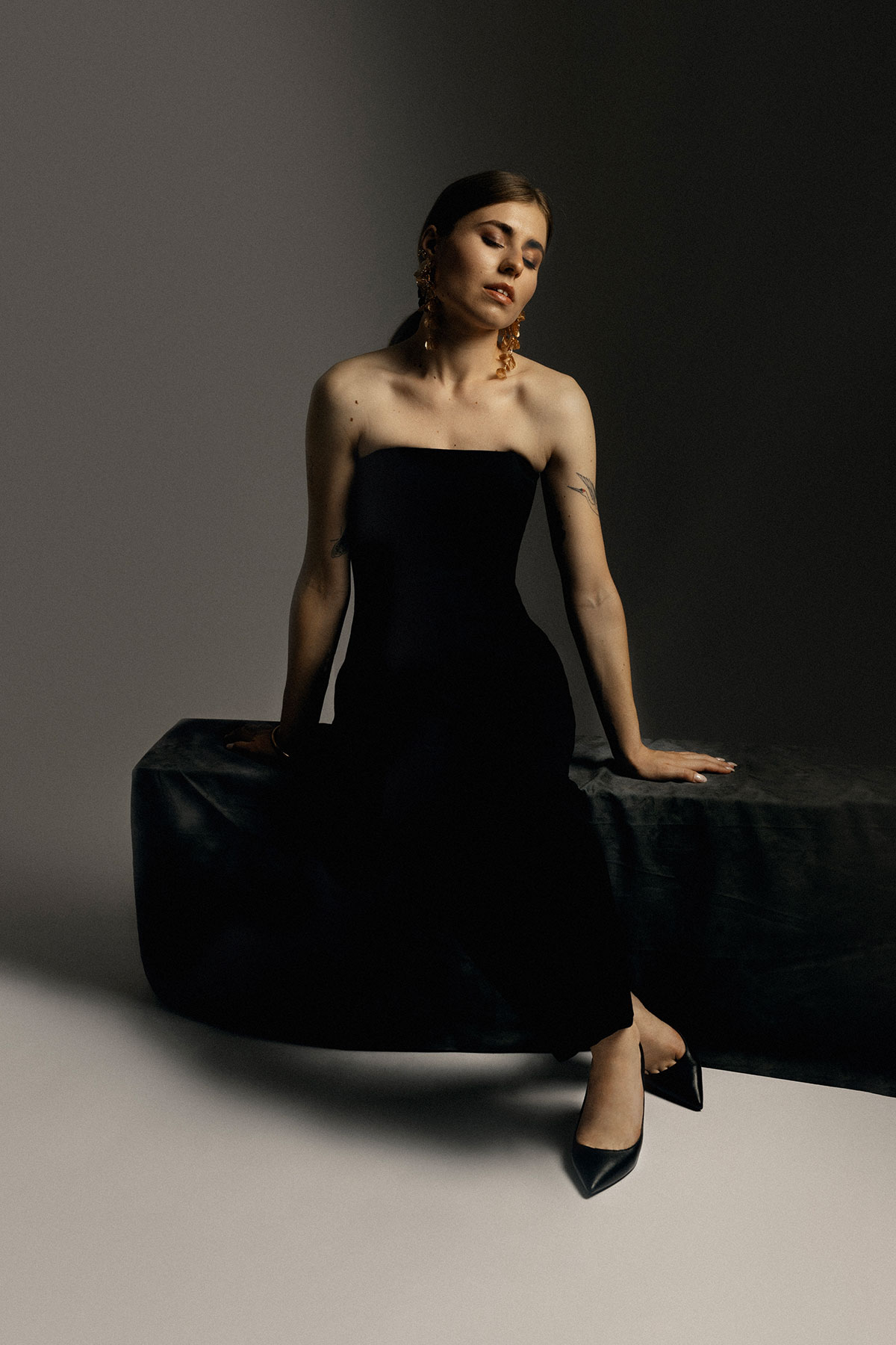 Retrato feminino editorial em estúdio, vestido preto elegante e pose minimalista — fotografia por Danniela Senra em Castelo Branco