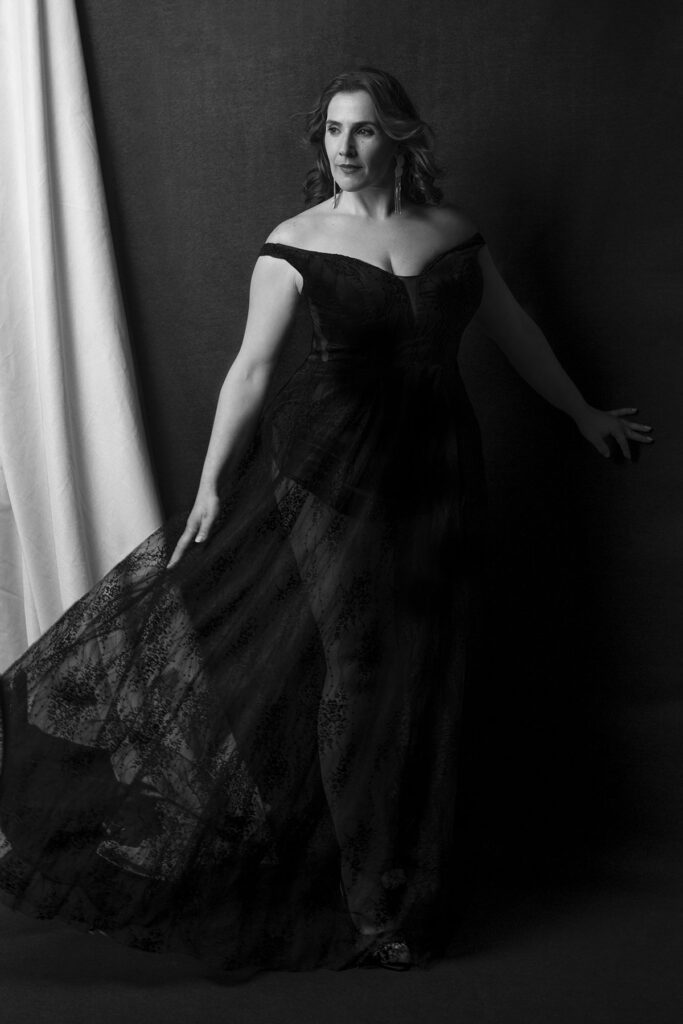 retrato em preto e branco de uma mulher com vestido preto longo e decotado