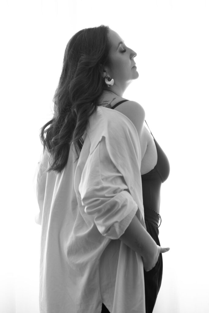 Retrato feminino editorial em estúdio, em preto e branco, de perfil, com camisa branca e top ajustado