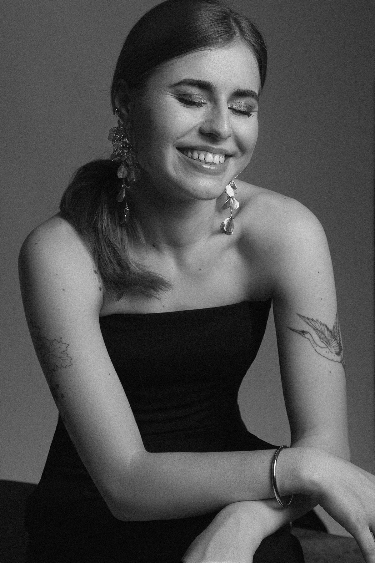 Retrato feminino em estúdio, em preto e branco, com expressão sorridente