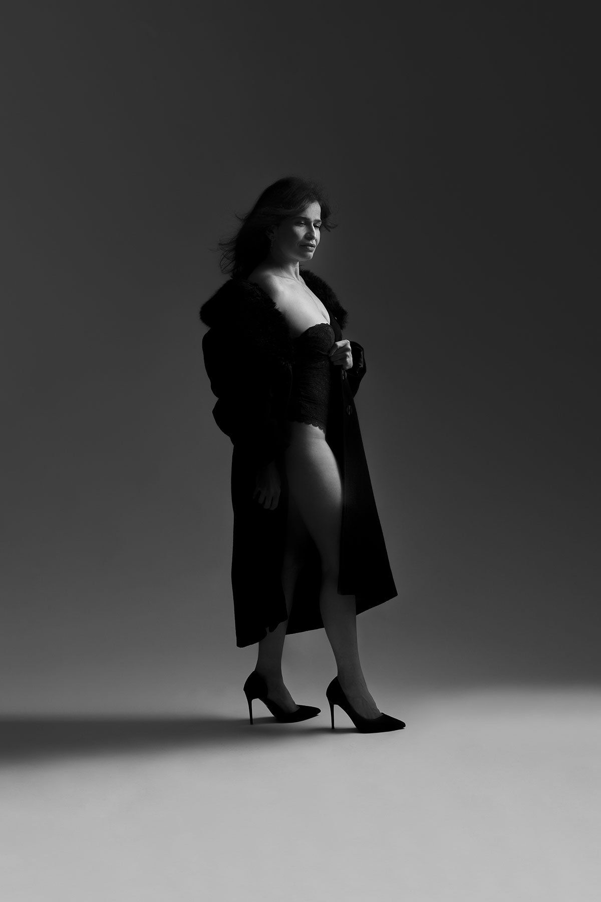 retrato feminino boudoir intimista em estúdio em preto e branco com casaco longo e saltos altos danniela senra