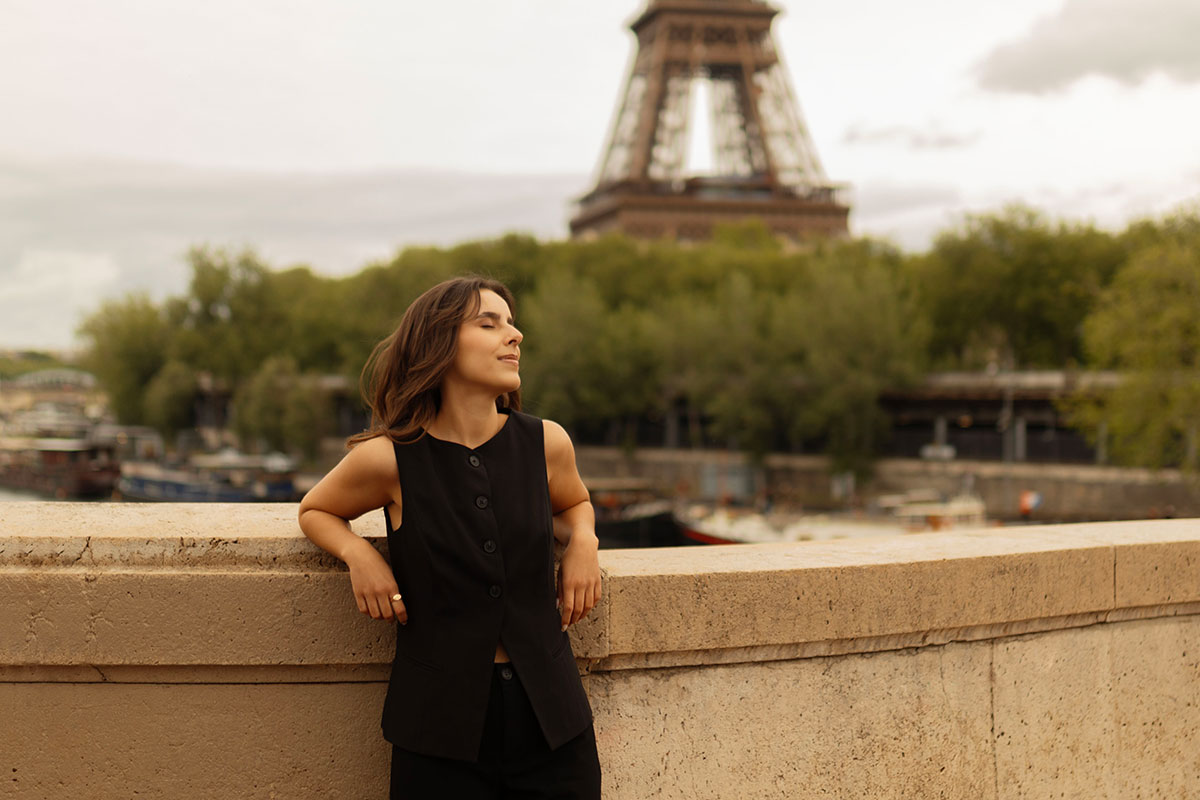 retrato de uma mulher em paris onde se vê a torre eiffel