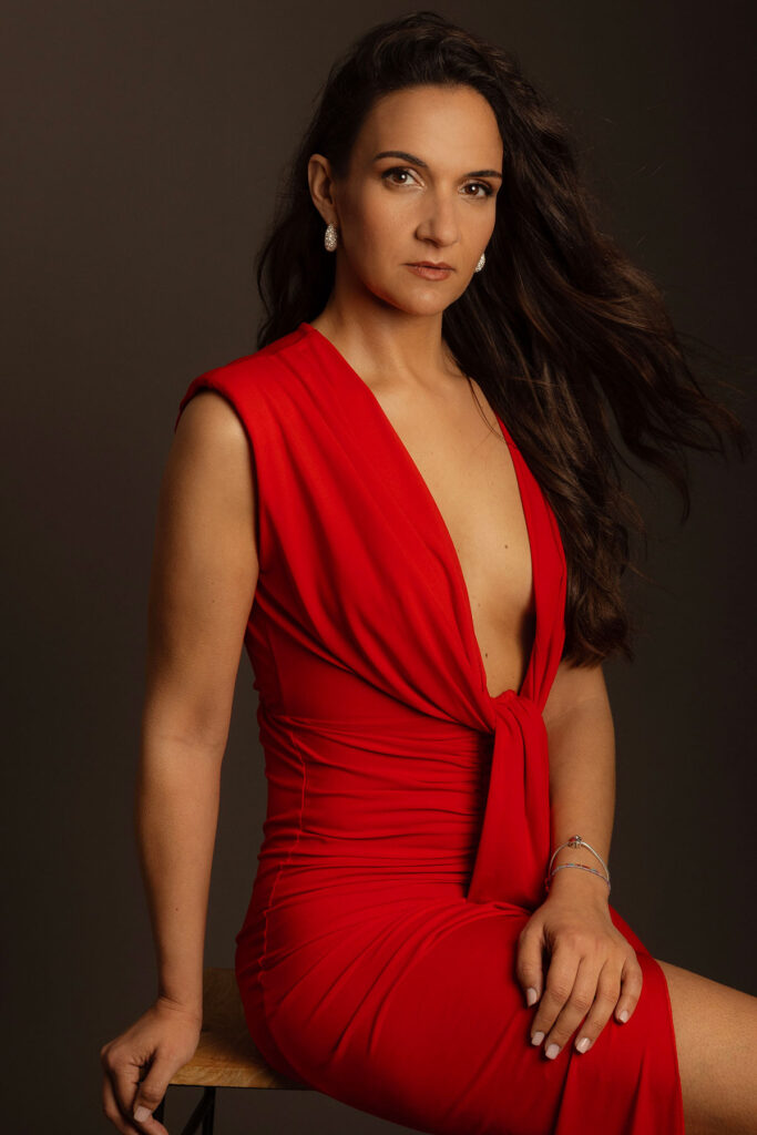 retrato feminino em estúdio com vestido vermelho e expressão confiante por danniela senra
